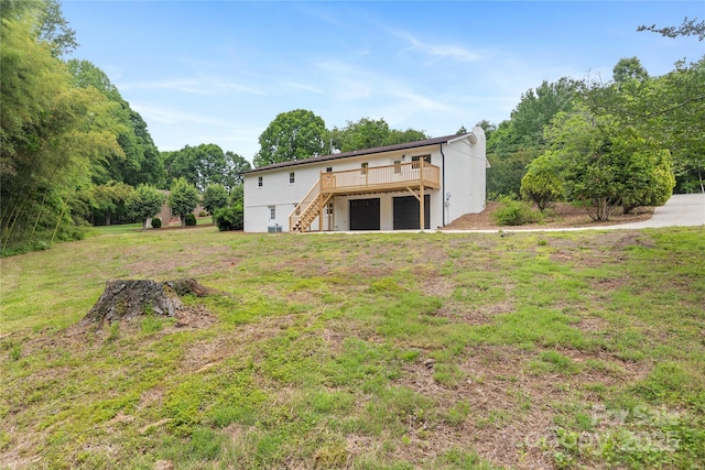 1904 27th Avenue Dr NE, Hickory, NC 28601 - rear view of property featuring stairway, a deck, a lawn, a garage, and stucco siding