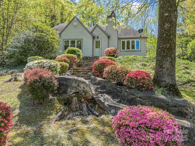 view of front of property featuring a shingled roof and a chimney