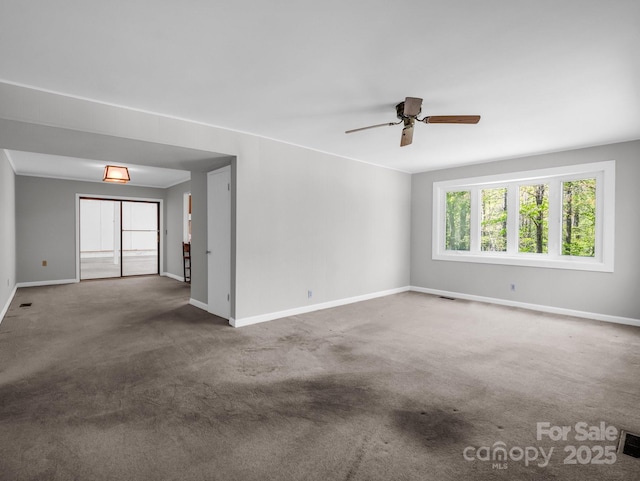 carpeted empty room featuring ceiling fan, baseboards, and visible vents