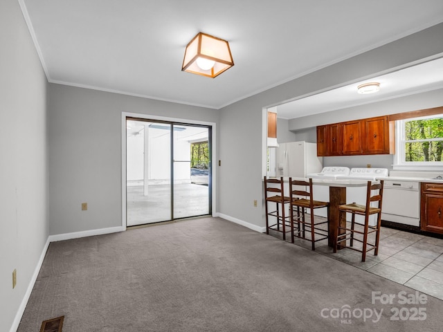 kitchen with washing machine and dryer, white appliances, ornamental molding, and visible vents
