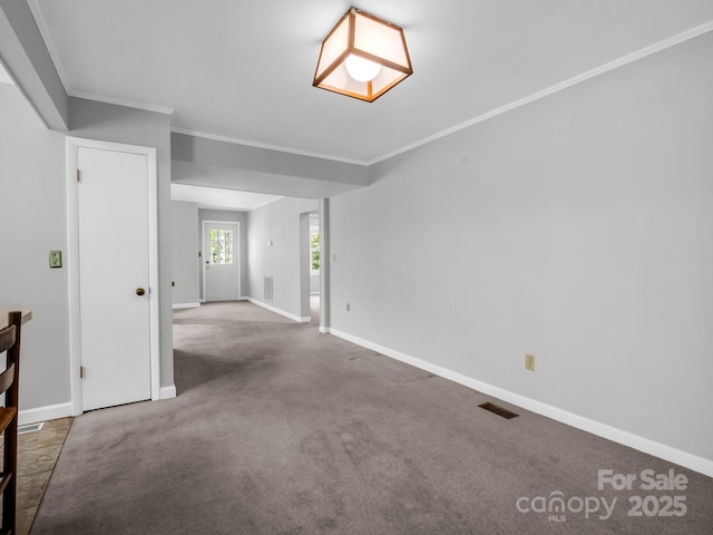 interior space with baseboards, crown molding, and visible vents