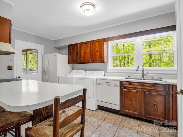 laundry area featuring a sink, separate washer and dryer, light tile patterned flooring, ornamental molding, and laundry area