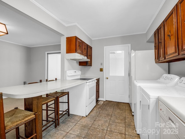 kitchen featuring a kitchen breakfast bar, under cabinet range hood, separate washer and dryer, a peninsula, and electric range