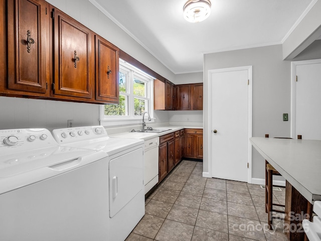 laundry room with ornamental molding, washing machine and dryer, cabinet space, and a sink