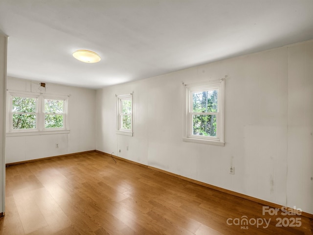 spare room featuring wood finished floors and baseboards