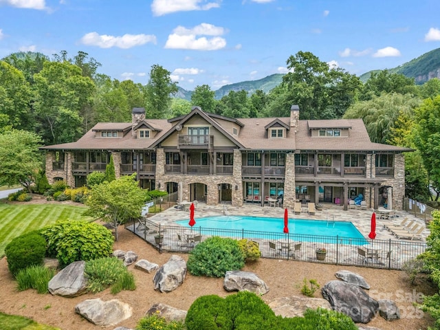 136 Firefly Cv, Lake Lure, NC 28746 - back of property featuring a balcony, stone siding, a chimney, and a patio area