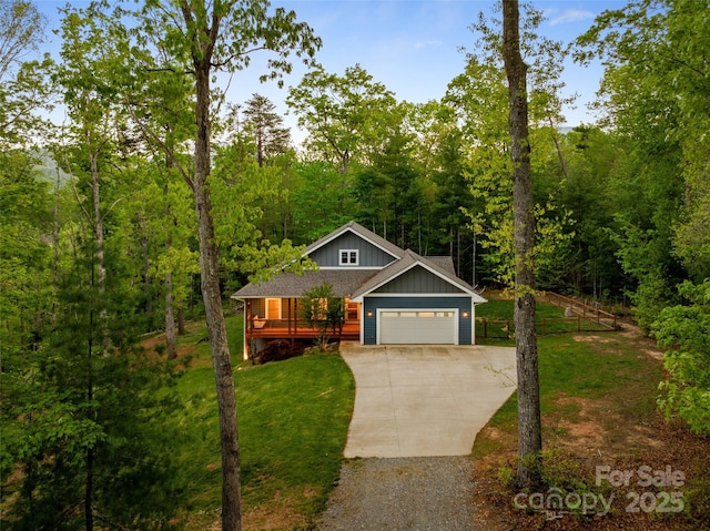 view of front of home featuring a front lawn, board and batten siding, an attached garage, a view of trees, and driveway