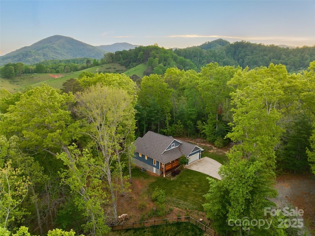 drone / aerial view with a wooded view and a mountain view