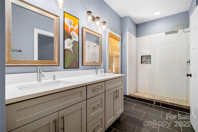 bathroom with double vanity, tile patterned floors, walk in shower, and a sink