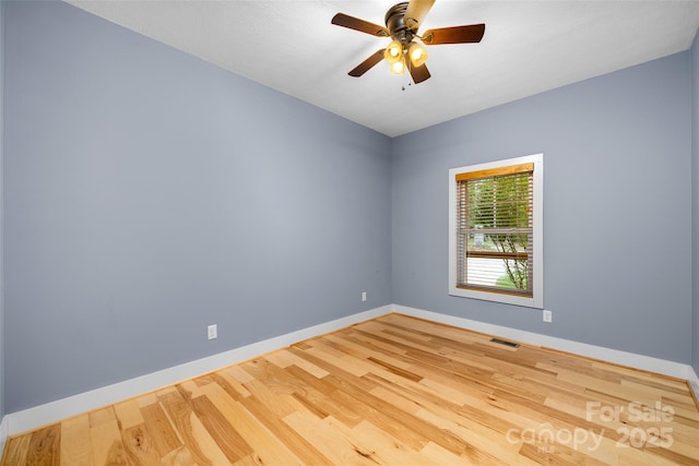 unfurnished room featuring ceiling fan, baseboards, visible vents, and wood finished floors