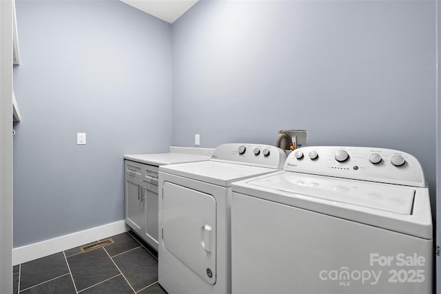 clothes washing area featuring washing machine and clothes dryer, cabinet space, baseboards, dark tile patterned floors, and visible vents