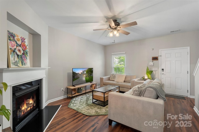 8917 Chalkstone Rd, Charlotte, NC 28216 - living room with dark wood-style floors, a ceiling fan, a lit fireplace, baseboards, and visible vents
