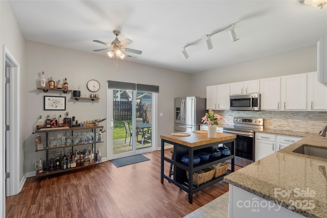 8917 Chalkstone Rd, Charlotte, NC 28216 - kitchen featuring stainless steel appliances, rail lighting, a sink, light stone countertops, and decorative backsplash