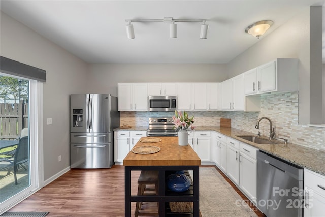 8917 Chalkstone Rd, Charlotte, NC 28216 - kitchen with white cabinets, light stone countertops, stainless steel appliances, and a sink