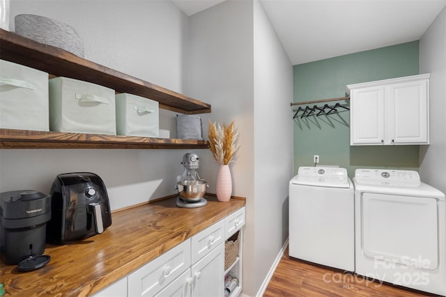 8917 Chalkstone Rd, Charlotte, NC 28216 - laundry room with washing machine and dryer, baseboards, cabinet space, and wood finished floors
