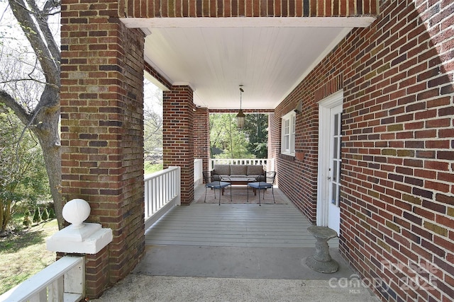wooden terrace featuring an outdoor living space and a porch