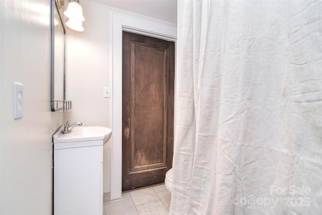 full bathroom with toilet, tile patterned flooring, and vanity