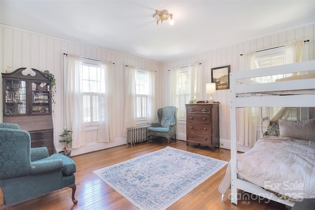 bedroom with radiator heating unit and hardwood / wood-style flooring
