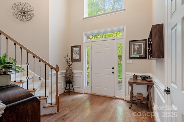 4516 Stryker Dr, Matthews, NC 28104 - entrance foyer featuring a decorative wall, a towering ceiling, wainscoting, and hardwood / wood-style flooring