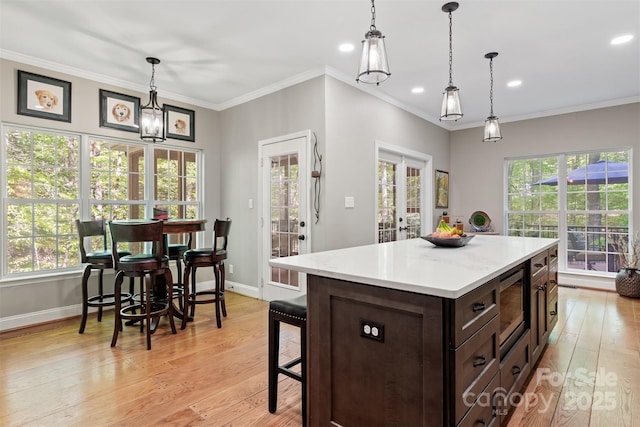 4516 Stryker Dr, Matthews, NC 28104 - kitchen with a kitchen breakfast bar, stainless steel microwave, light wood-style flooring, light countertops, and baseboards