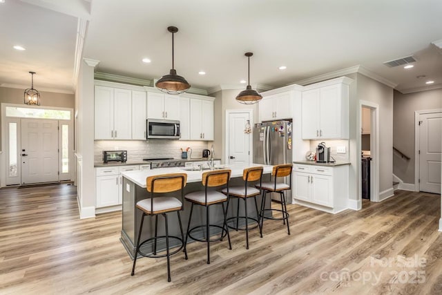 4594 N Wynswept Dr, Maiden, NC 28650 - kitchen featuring stainless steel appliances, a breakfast bar, visible vents, and crown molding
