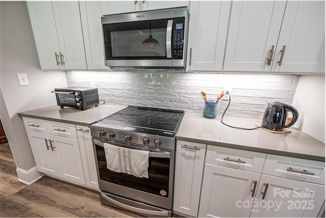 4594 N Wynswept Dr, Maiden, NC 28650 - kitchen with a toaster, white cabinetry, wood finished floors, and stainless steel appliances