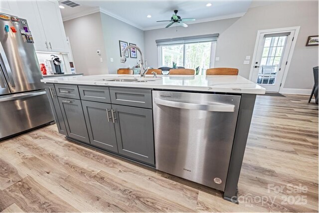 4594 N Wynswept Dr, Maiden, NC 28650 - kitchen featuring gray cabinets, ornamental molding, a sink, light wood-style floors, and appliances with stainless steel finishes