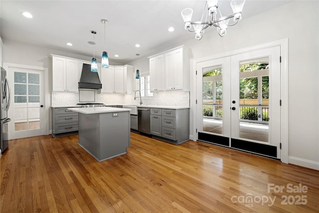 kitchen featuring premium range hood, tasteful backsplash, gray cabinets, and stainless steel appliances