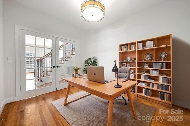 office space with plenty of natural light, baseboards, and wood finished floors