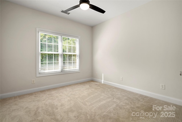 empty room featuring ceiling fan, baseboards, visible vents, and light carpet