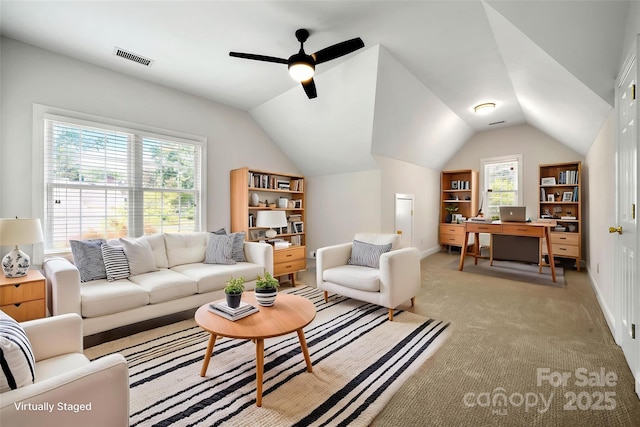 living room featuring lofted ceiling, ceiling fan, baseboards, and light colored carpet