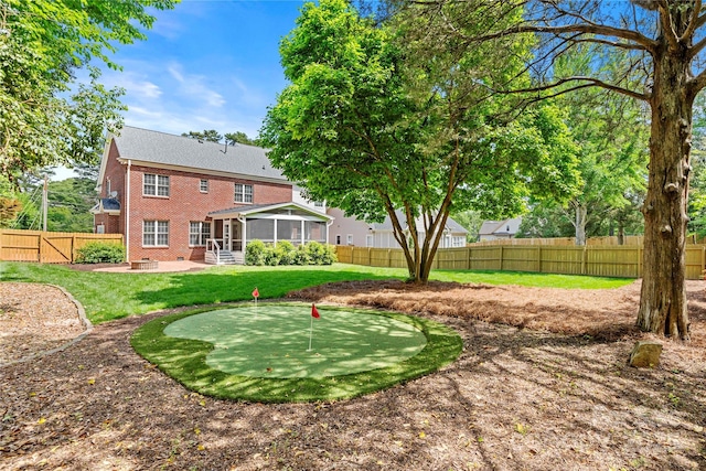 view of yard featuring a patio area, a fenced backyard, and a sunroom