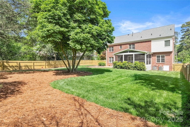 view of yard featuring a fenced backyard and a sunroom