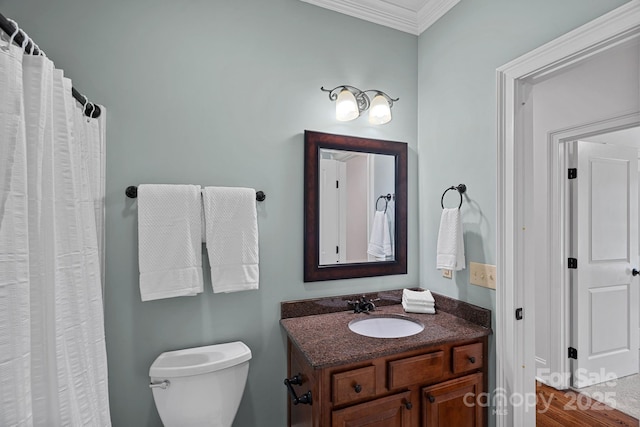 bathroom featuring toilet, ornamental molding, and vanity
