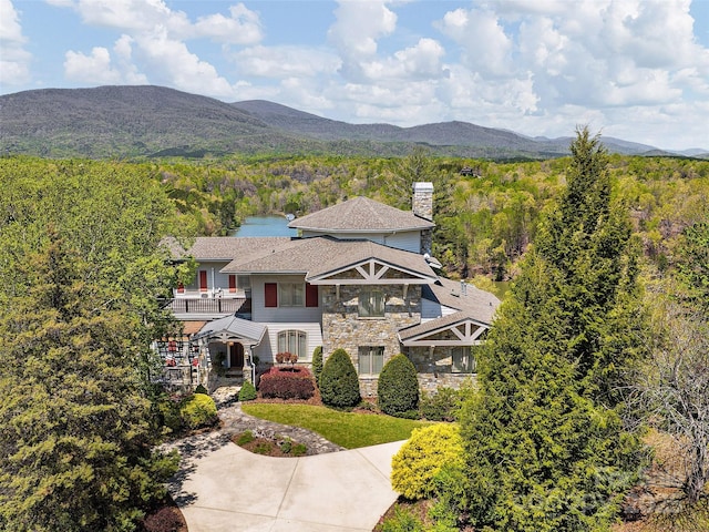 birds eye view of property with a wooded view and a mountain view