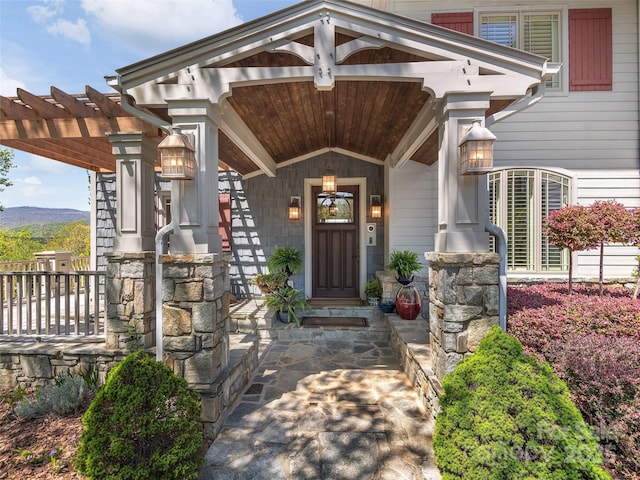 entrance to property featuring covered porch and a pergola