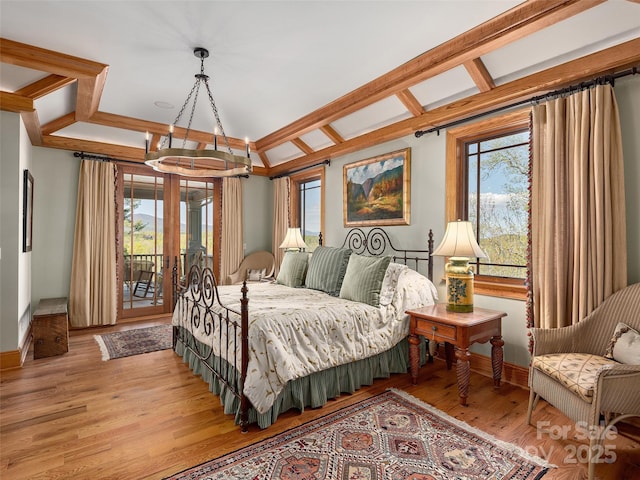 bedroom featuring a chandelier, light wood-style floors, access to exterior, and baseboards