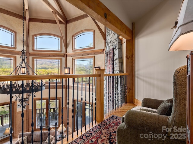 interior space with wood finished floors, high vaulted ceiling, baseboards, and beam ceiling