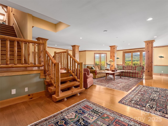 living area with crown molding, wood finished floors, recessed lighting, and stairway