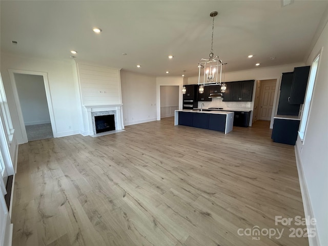 kitchen with recessed lighting, open floor plan, a sink, and tasteful backsplash