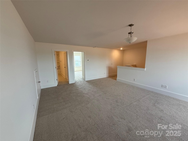 spare room with baseboards and carpet flooring