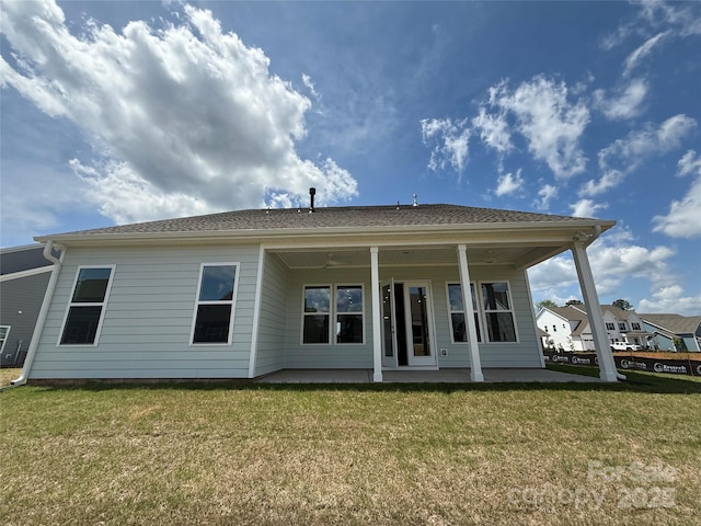 rear view of property featuring a yard