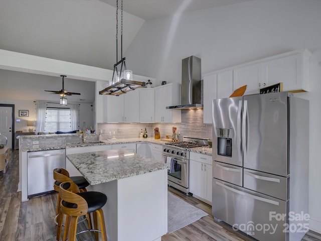 1488 Meadow Glen Ln, Rock Hill, SC 29730 - kitchen featuring appliances with stainless steel finishes, wall chimney exhaust hood, high vaulted ceiling, a peninsula, and wood finished floors