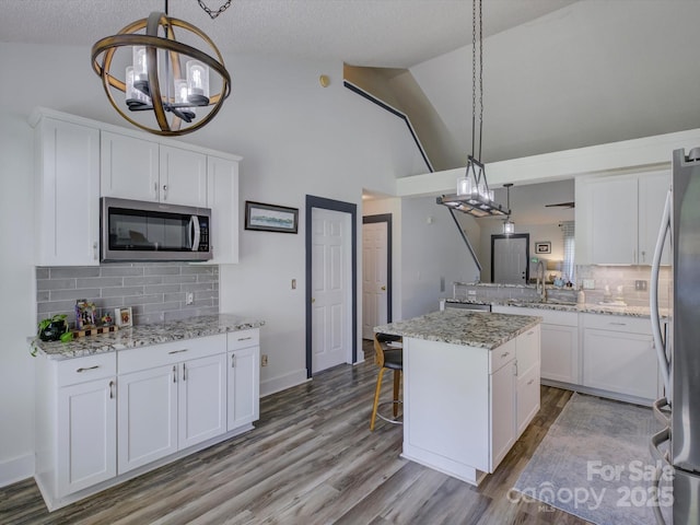 1488 Meadow Glen Ln, Rock Hill, SC 29730 - kitchen with appliances with stainless steel finishes, a chandelier, a sink, white cabinets, and high vaulted ceiling