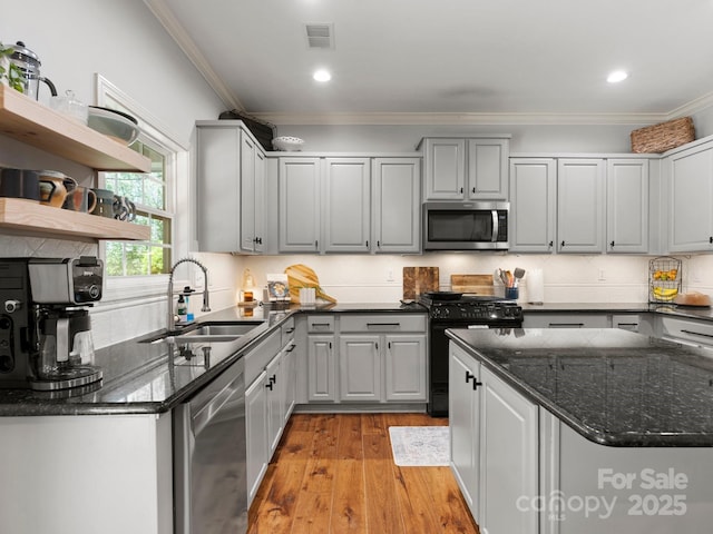 kitchen with gray cabinets, crown molding, appliances with stainless steel finishes, and a sink