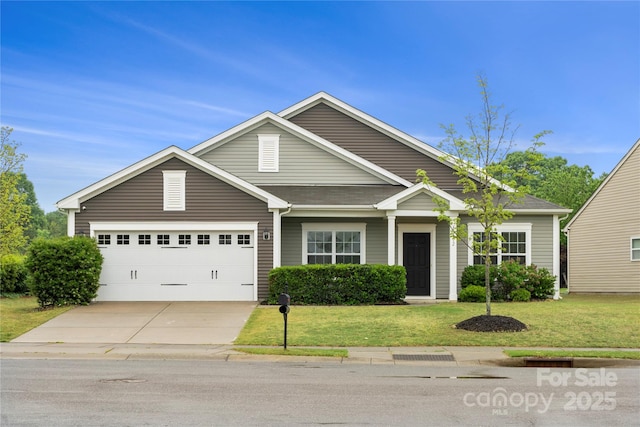 view of front of house with concrete driveway, a front lawn, and an attached garage