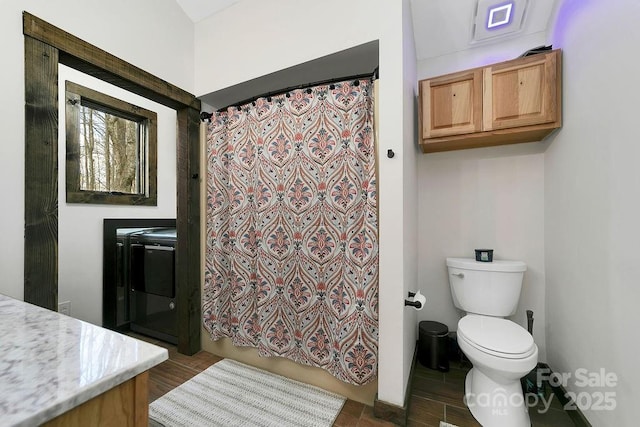 bathroom featuring independent washer and dryer, toilet, and vanity