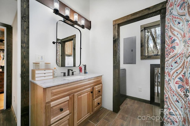 full bathroom with electric panel, baseboards, wood finished floors, and vanity