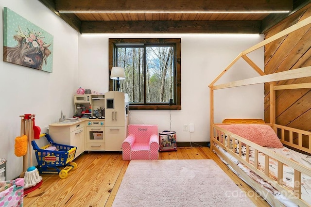 recreation room with beam ceiling, light wood finished floors, and wood ceiling