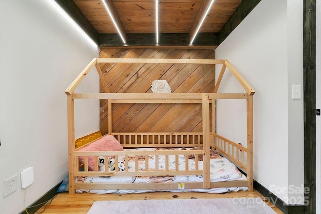 unfurnished bedroom with wood ceiling and beam ceiling